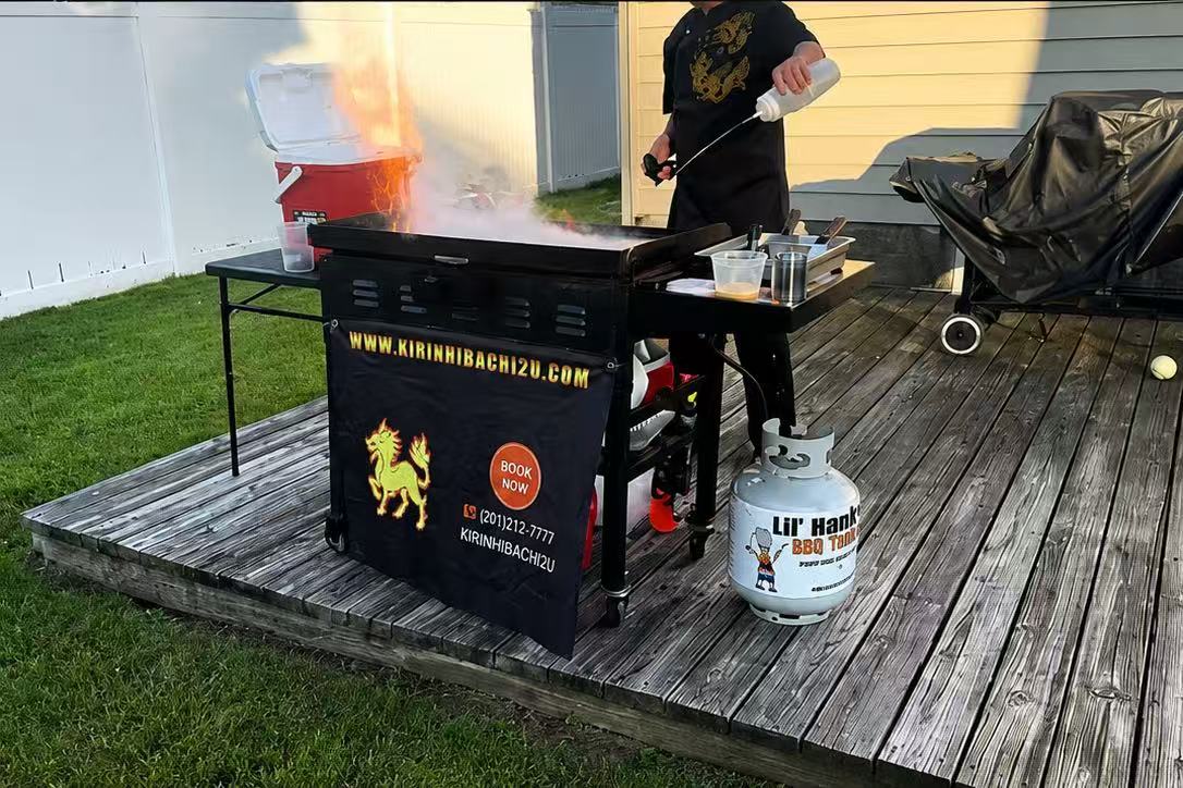 Kirin Hibachi Catering chef cooking on branded grill setup in a backyard deck